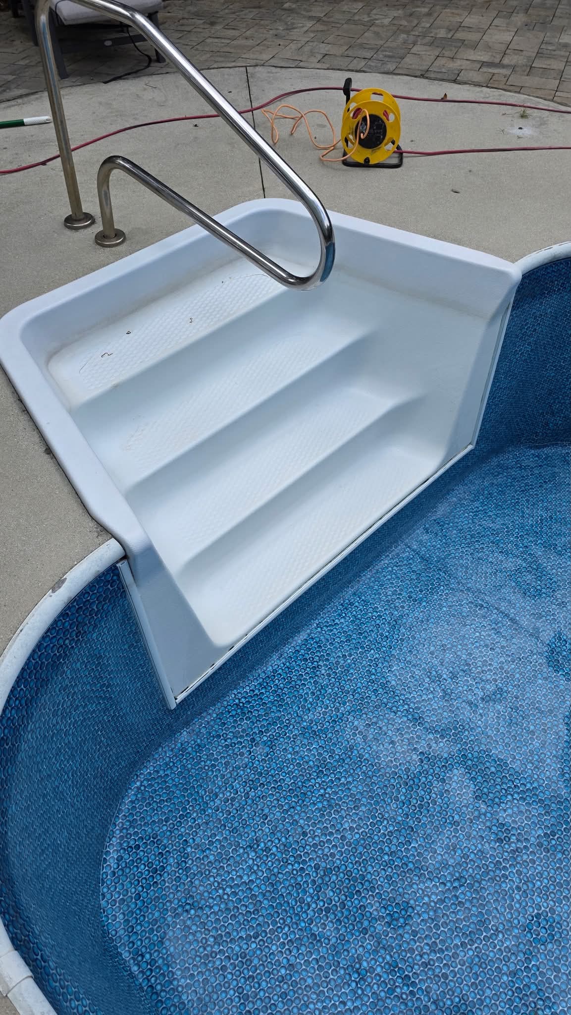 Light resurfaced steps leading into a blue pool