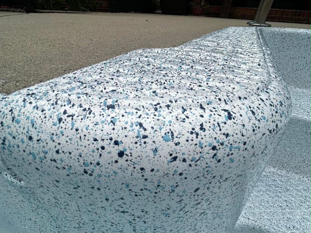 Speckled resurfaced coping or metal pool edge close-up