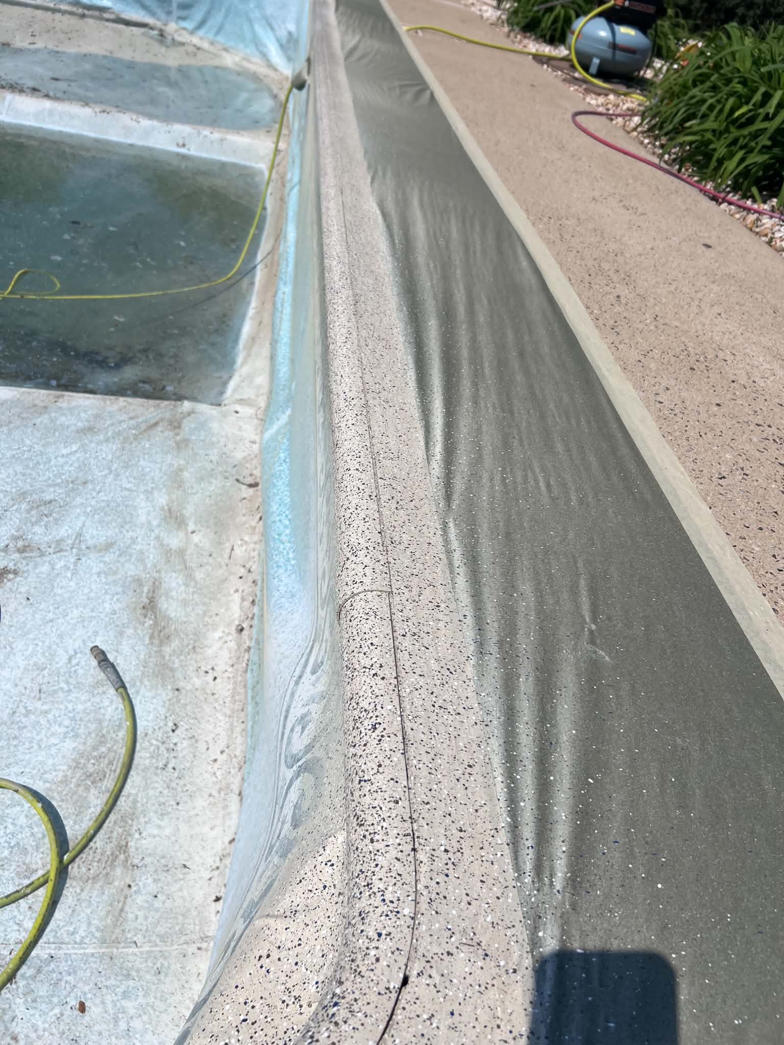 Long view of resurfaced coping or metal edging beside a vinyl pool