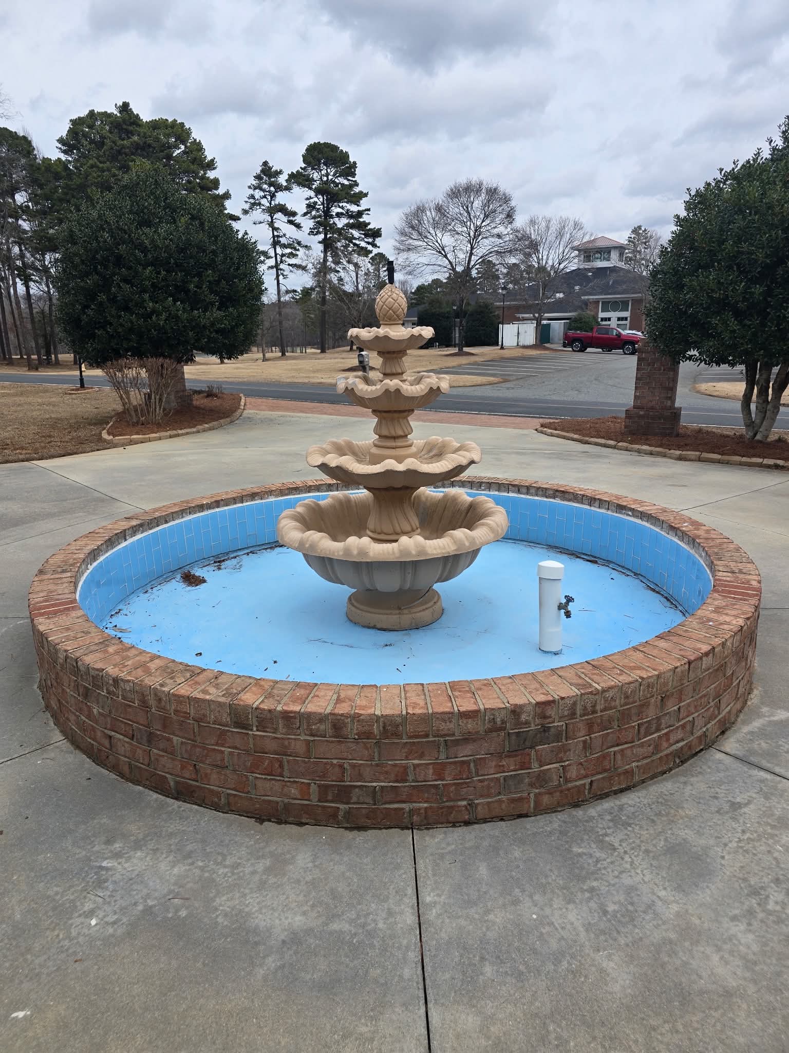 Worn blue courtyard fountain basin before resurfacing