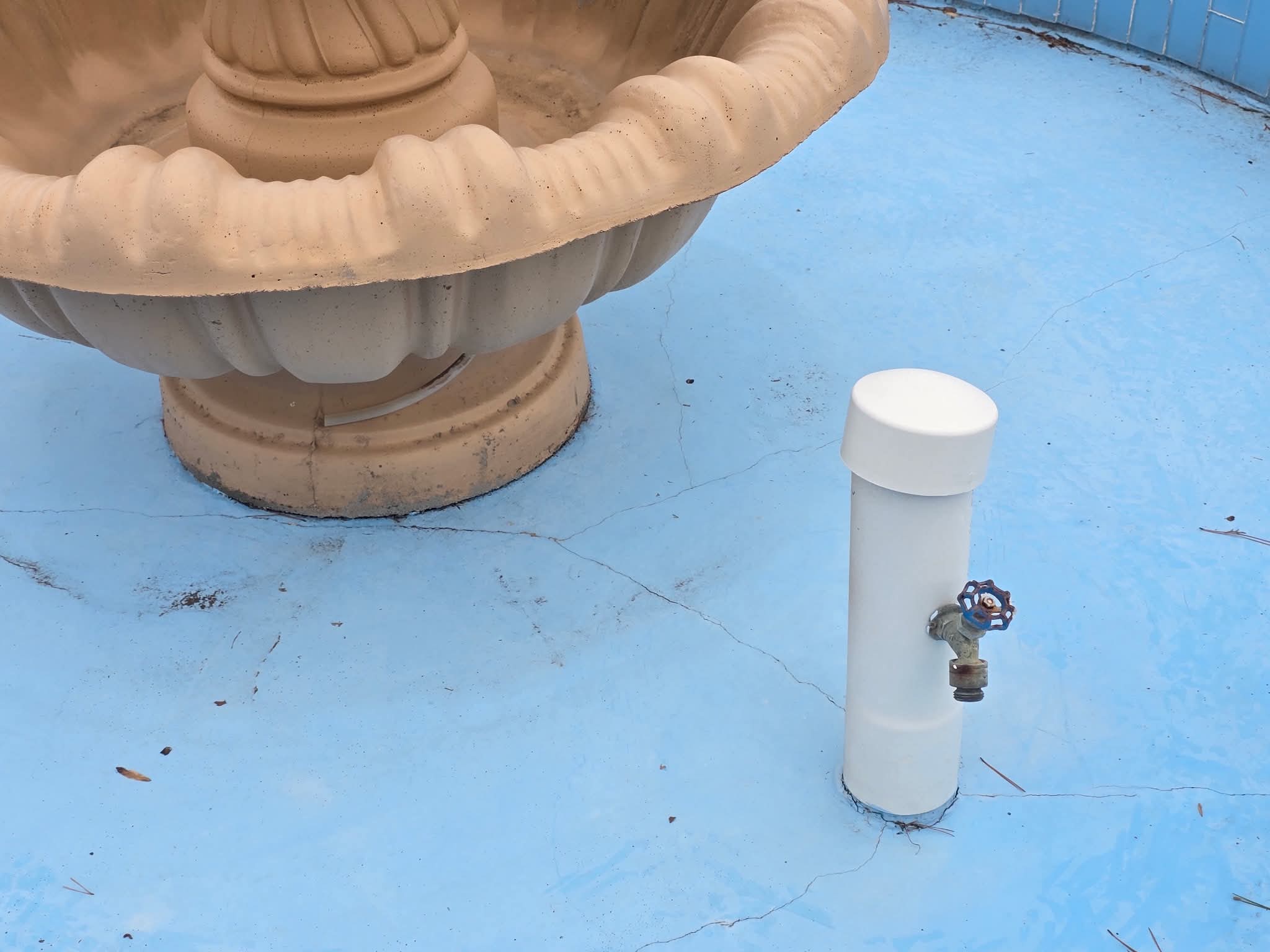 Cracked and stained fountain basin around plumbing