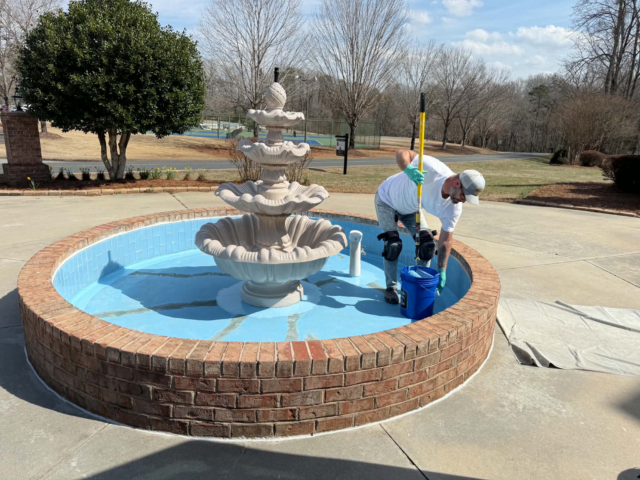 Technician resurfacing the courtyard fountain basin