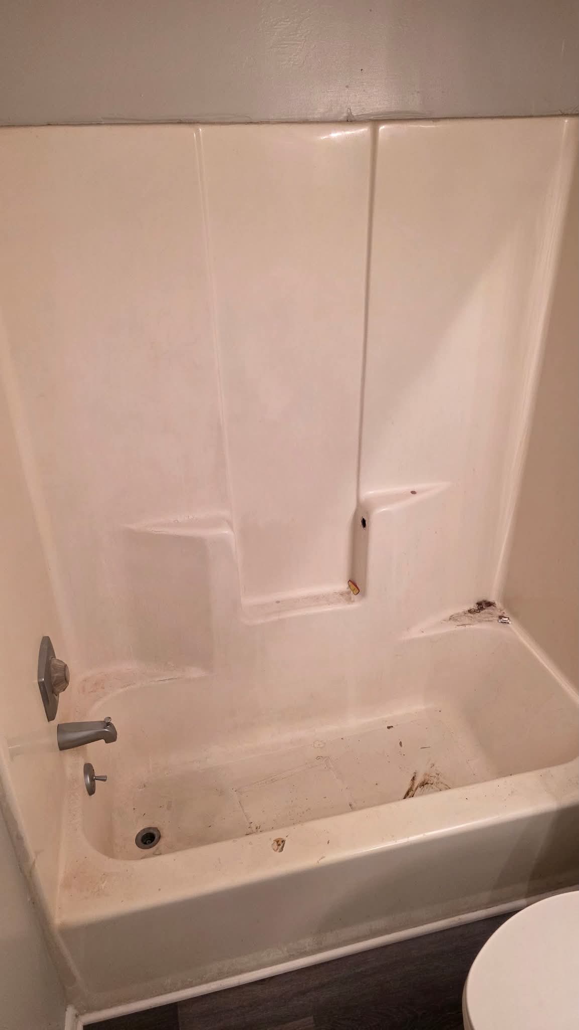 Worn beige tub and shower surround