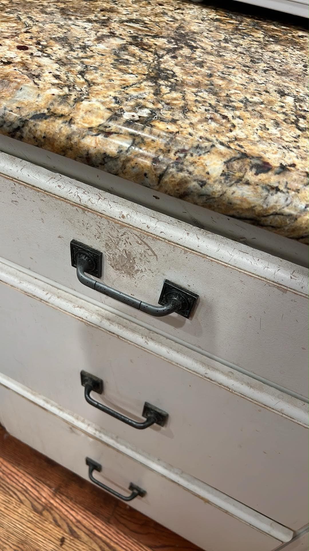 Worn cabinet drawer fronts and hardware before refinishing