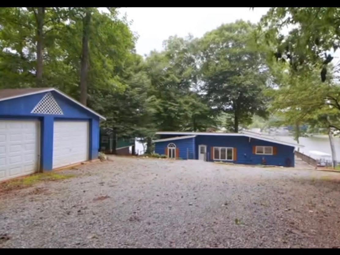 Driveway view of the house and garage with original blue exterior