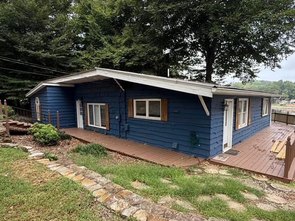 Blue lakefront house with brown shutters before painting