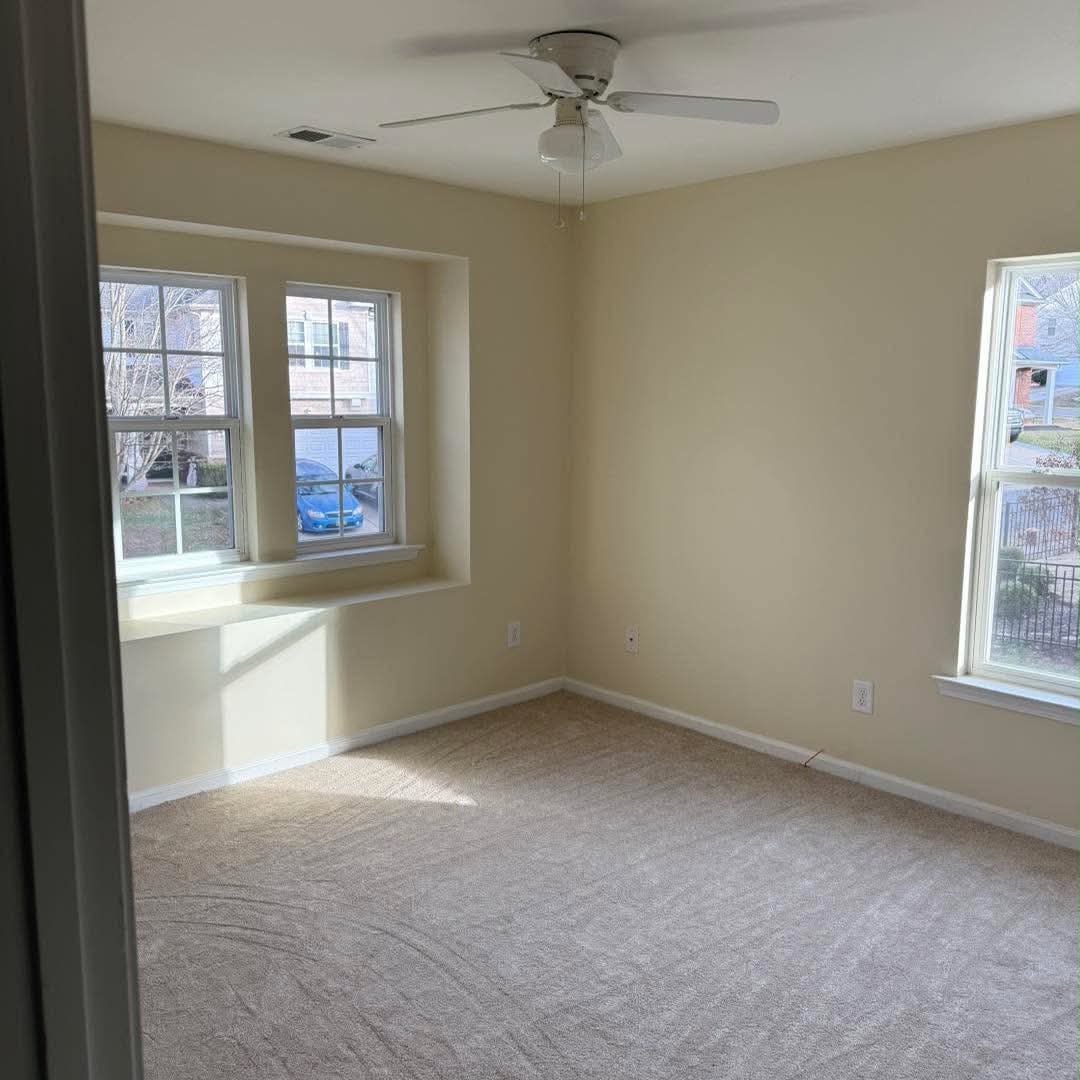 Bedroom with cream walls, white window trim, and a white ceiling